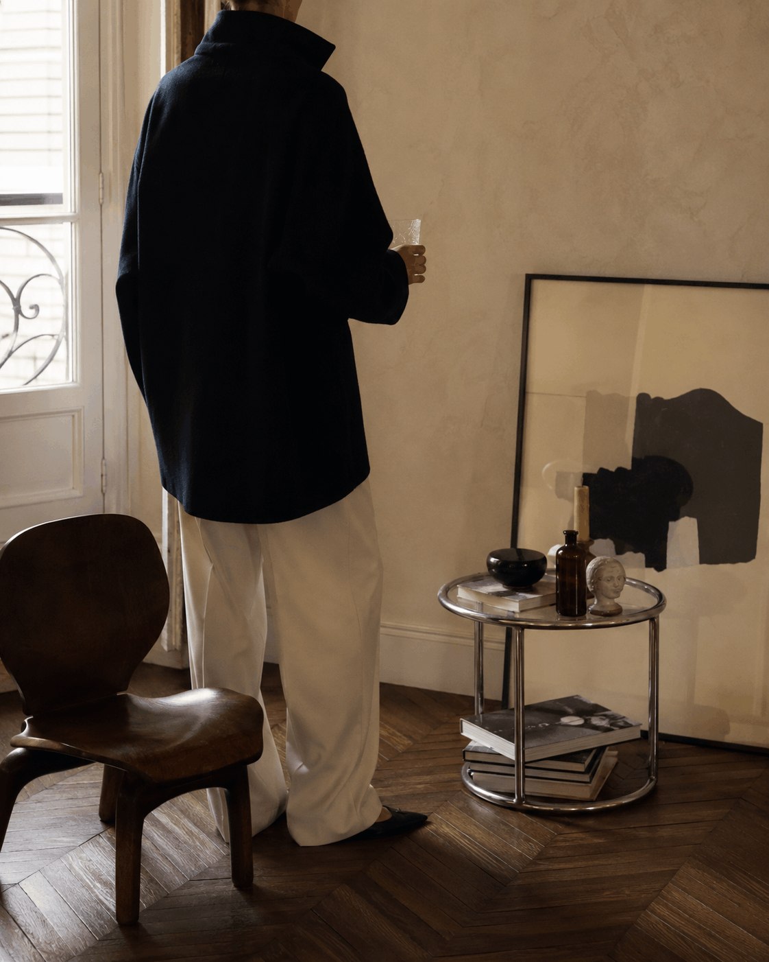 A quiet European interior with clothing, art and personal objects
